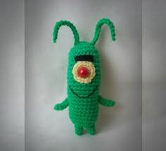 crocheted green creature with red nose and eyes