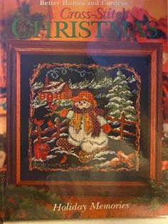 a cross stitch christmas book with an image of a santa clause