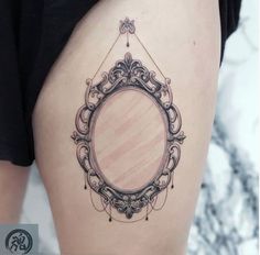 a woman's thigh with a mirror tattoo on it