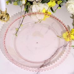 a glass plate with flowers and candles on a table