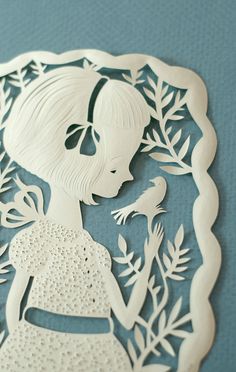 a paper cut out of a girl and bird