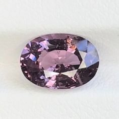 an oval shaped pink diamond on a white surface