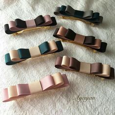 four different colored hair clips sitting on top of a white towel next to each other