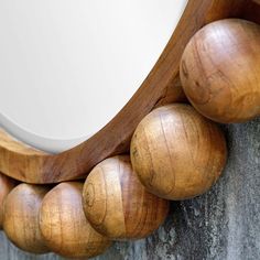 a mirror that is on the side of a wall with wooden balls around it,