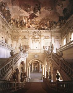 an ornate building with many paintings on the ceiling and stairs leading up to the second floor