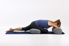 a woman is laying on her stomach while doing an upward back stretch with a yoga mat in front of her