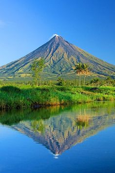 a large mountain is reflected in the water