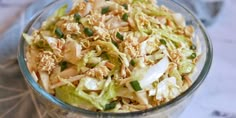 a glass bowl filled with coleslaw salad on top of a table