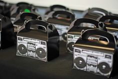 some black and white boomboxs are lined up on a table with headphones