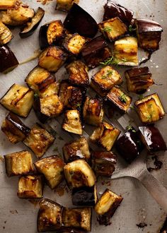 roasted eggplant and potatoes on a baking sheet with a spatula next to them