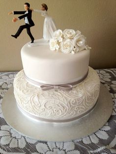 a wedding cake with a bride and groom figurine on top