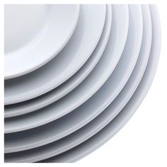 a stack of white plates sitting on top of each other in front of a white background