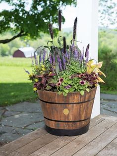 a wooden barrel filled with lots of flowers