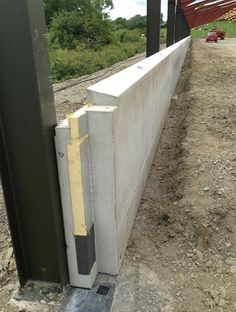 the side of a building that is being built with concrete and steel bars attached to it