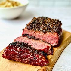 two pieces of meat sitting on top of a cutting board