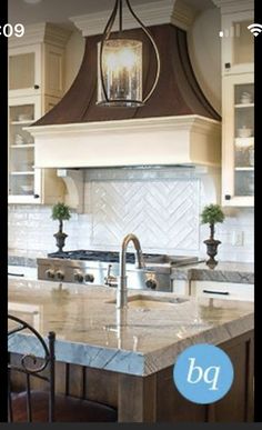 a large kitchen with an island in the middle and two chairs at the counter top