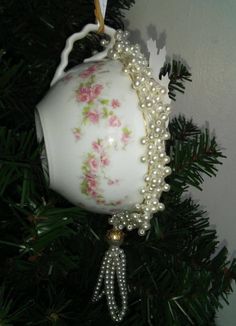 an ornament hanging from a christmas tree decorated with flowers and pearls on it