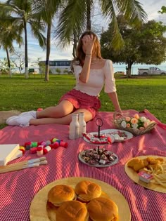 a woman sitting on the ground with food in front of her and other foods around her