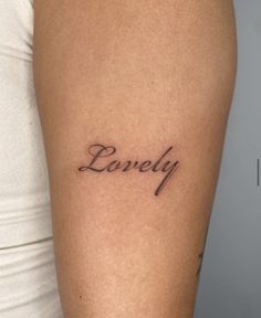 a woman's arm with the word lovely tattooed on her left side ribcage