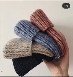 there are four knitted hats on top of each other in different colors and sizes