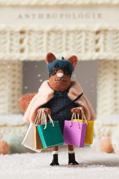 a teddy bear holding shopping bags in its hands