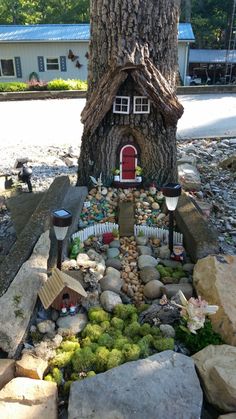 a fairy house built in the rocks under a tree