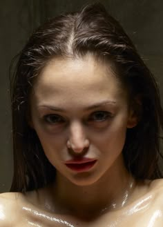 a woman with wet skin on her face and chest is looking at the camera while posing for a photo