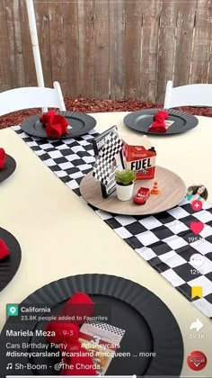 the table is set with black and white checkered cloths, red napkins, and plates