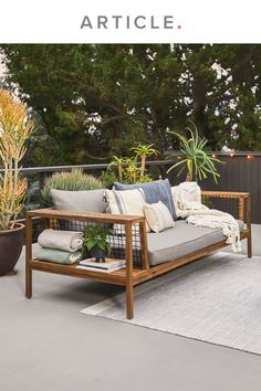 a couch sitting on top of a patio next to plants