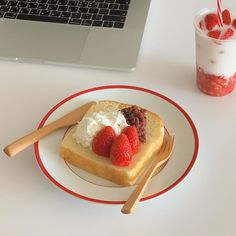 a piece of toast with whipped cream and strawberries on it next to a drink