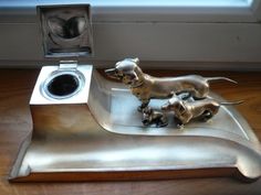 two little dogs are sitting on top of a silver dish that is shaped like a washing machine