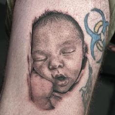 a close up of a person's arm with a tattoo on it and an image of a baby