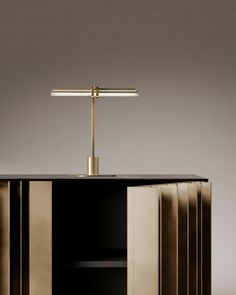 a black and gold cabinet with a lamp on top