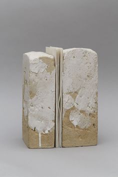 an open book that is made out of concrete and has white paint on the pages