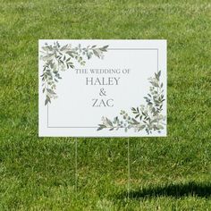 a wedding sign sitting in the grass