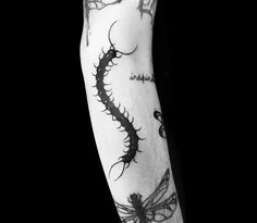 a black and white photo of a dragon tattoo on the arm