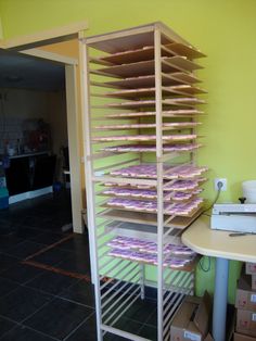 a stack of donuts sitting on top of a wooden rack next to a table