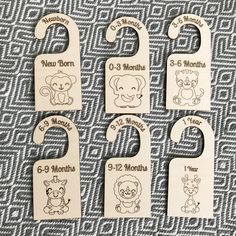 four wooden baby's name tags with animals on them, one for each month