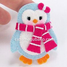 a small penguin with a scarf on it's head is being held by someone