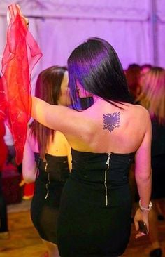 a woman with purple hair and tattoos on her back