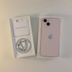 an apple phone is in its box with the charger plugged into it