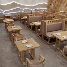 an empty restaurant with wooden tables and chairs on the floor, in front of a white wall