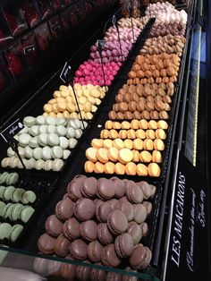 a display case filled with lots of different colored donuts