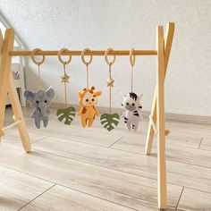 three stuffed animals are hanging on the clothes pegs in front of a wooden floor