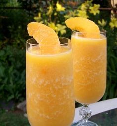 two glasses filled with orange juice on top of a table