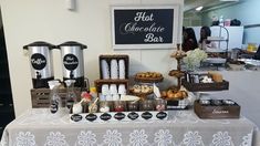 an assortment of food is displayed on a white tablecloth at a coffee tasting event