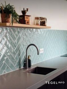 a kitchen sink sitting under a window next to a counter top with a faucet