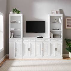 a living room with white cabinets and a flat screen tv on top of the entertainment center