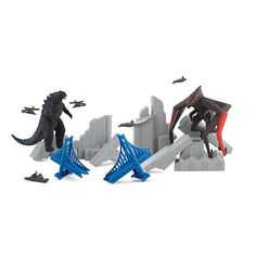 godzilla and other toy figures in front of a cityscape with an airplane flying over them