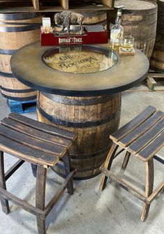 two wooden stools sitting next to a table with wine bottles on top of it